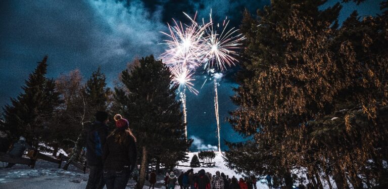 Fireworks over a treeline at a ski resort