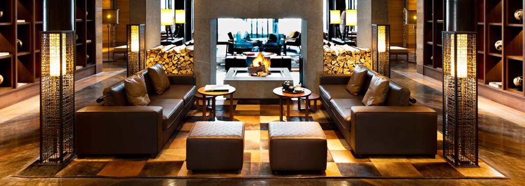 A luxurious seating area in The Chedi Andermatt hotel in front of a fire
