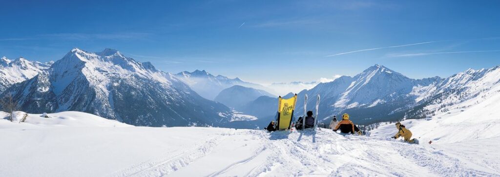 A group of skiers relaxing in front of a view of mountains