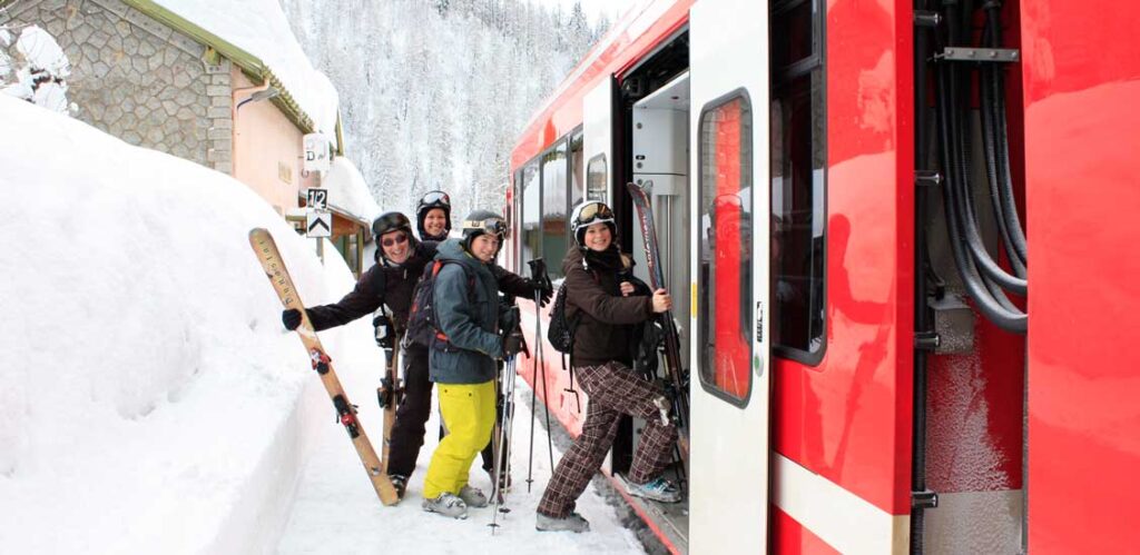 A family of skiers boarding a train at a ski resort