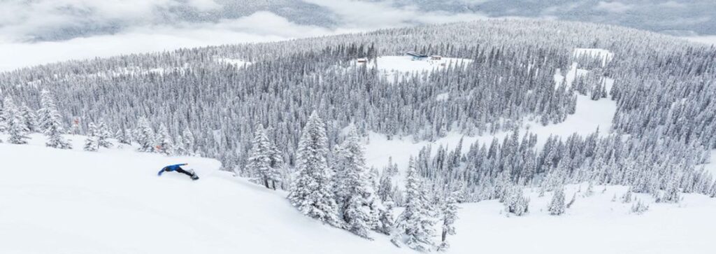 A view of a snowboarder going down a mountain in Revelstoke, North America