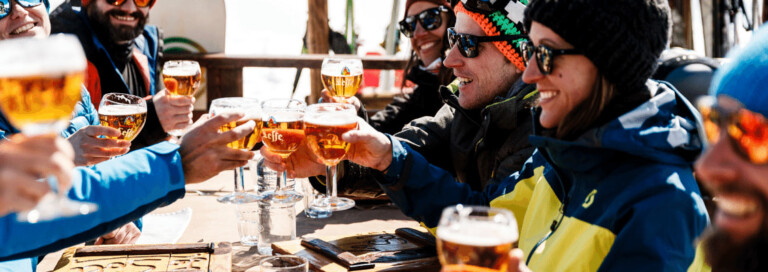 A group of friends enjoying a beer at a mountainside restaurant