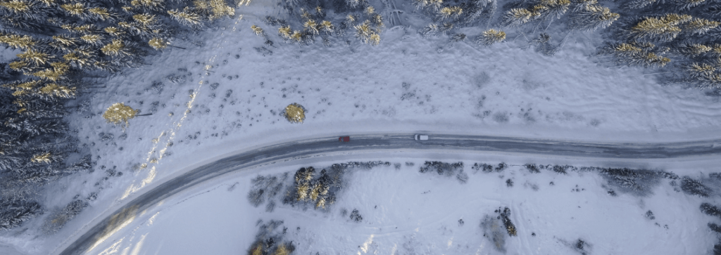 A top-down view of two cars driving down a snowy road
