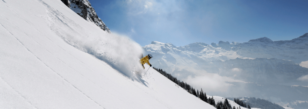 A skier skiing through powder snow on a steep mountain in Europe