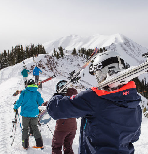 Group of skiers hiking up a mountain for freeskiing