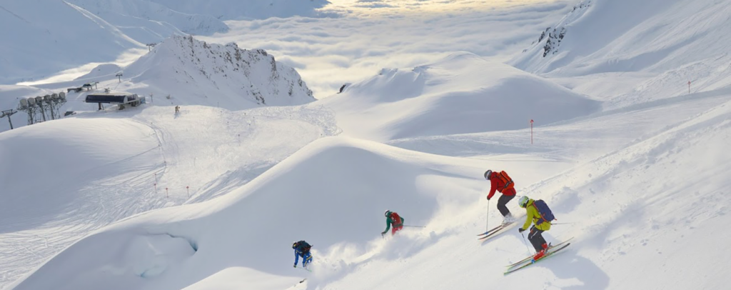Group of skiers carving through powder