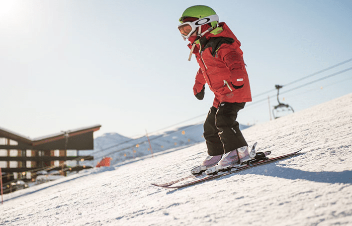 A child learning to ski down a slope